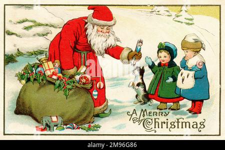 Father Christmas opens his toy sack to present two little children with Christmas presents. A small dog stands expectantly on his hind-legs hoping for a gift from Santa too. Stock Photo