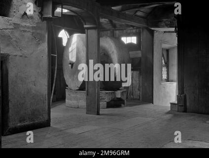 Interior view of a mill with two round millstones at the centre. Stock Photo