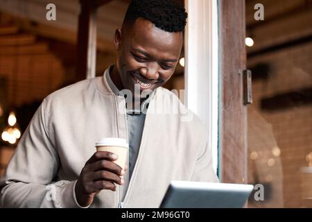 Always ready to laugh. a businessman taking a break at a cafe to drink coffee while using a digital tablet. Stock Photo