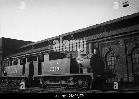Two LNER (London & North Eastern) steam engines on a railway track alongside a building. Stock Photo