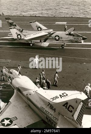 A Vought F8U Crusader manoeuvres past Douglas A-4C Skyhawk, 147814, aboard USS Independence. Stock Photo