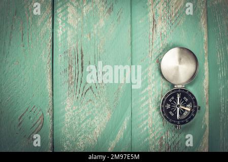 Compass with an open lid on a vintage old table. Stock Photo