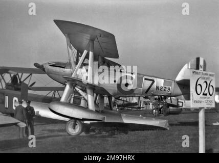 Seaplane in a field, with two men in uniform standing alongside. Stock Photo