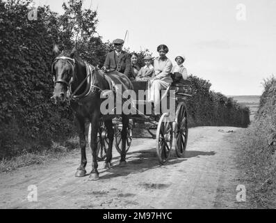 People on a horse-drawn cart on a country lane. Stock Photo