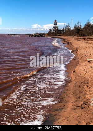West Point Lighthouse and red ocean after a hurricane, Cedar Dunes Provincial Park, Prince Edward Island, Canada Stock Photo