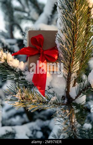 Close-up of a gift box on a snow-covered Christmas tree Stock Photo