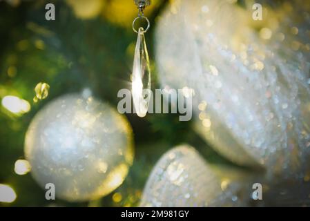 Close-up of a crystal ornament and Christmas baubles hanging on a Christmas tree Stock Photo