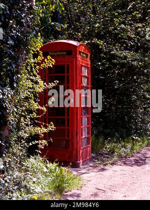 Old style telephone box in a quiet country village road. Stock Photo