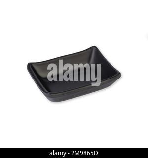 Small black ceramic plate isolated over white background. Stock Photo