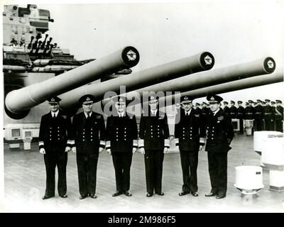 King George VI on the quarterdeck of HMS Duke of York, Scapa Flow, WW2.  With him are Rear-Admiral J G Glennie, Rear-Admiral R L Burnett, Admiral Sir Bruce Fraser, Vice-Admiral Sir Henry Moore, and Rear-Admiral L H K Hamilton. Stock Photo