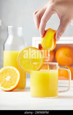 Woman making a glass of freshly squeezed orange juice Stock Photo