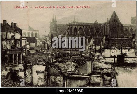 Louvain (Leuven), Belgium - damage in the Rue de Diest during WW1, with St Peter's Church on the right showing some damage to the roof, and the three spires of the Town Hall visible in the middle distance. Stock Photo