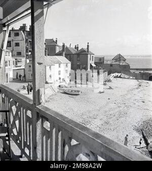 One of a great series of studies of St Ives, Cornwall.  The Wharf & Quay Street from Seagull Flats, Morning. The Harbour Beach Foresand, cottages & Quay House, St Leonard's Chapel, the Pilot's Office (now the Harbour Master's Office), punts on the beach & washing drying, so it's probably Monday. On the bottom right is the large sewer pipe at the bottom of the small slipway Curnow's Slip. Stock Photo