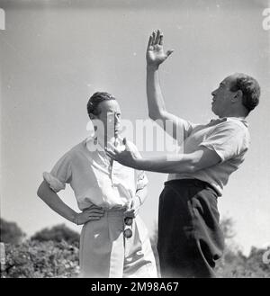 Leslie Howard (1893-1943), English actor, and Georges Perinal (1897-1965), French cinematographer, on location during the filming of The First of The Few, in which Howard played the Spitfire designer RJ Mitchell. Stock Photo