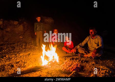 ZAGROS, IRAN - JULY 7, 2019: Nomad family preparing chicken barbecue in Zagros mountains, Iran Stock Photo
