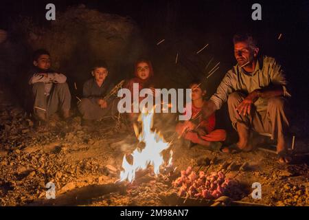 ZAGROS, IRAN - JULY 7, 2019: Nomad family preparing chicken barbecue in Zagros mountains, Iran Stock Photo