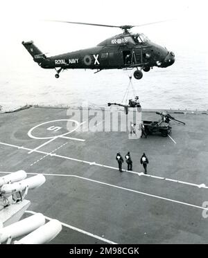 A Royal Navy Westland Wessex HU5, XT485, lifts supplies from HMS Hermes (R12). Stock Photo
