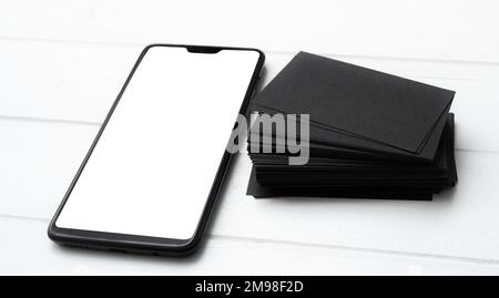 Blank of modern smartphone and black business cards stack for your design Stock Photo