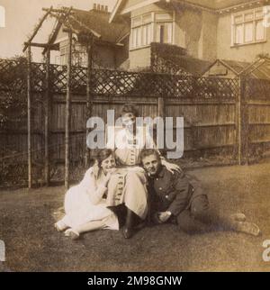 Soldier on leave, relaxing with his fiancee and her mother in a garden in Cheam, Surrey, during the First World War.  They are Albert Auerbach, Molly Bowie and Mrs Bowie. Stock Photo