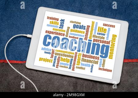 coaching - word cloud on a digital tablet against art paper landscape, business, career, lifestyle and sport concept Stock Photo