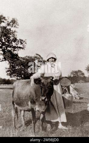 Milkmaid (Lucy Auerbach) and Midget the Jersey cow, in the village of Madresfield, near Malvern, Worcestershire, during the First World War. Stock Photo