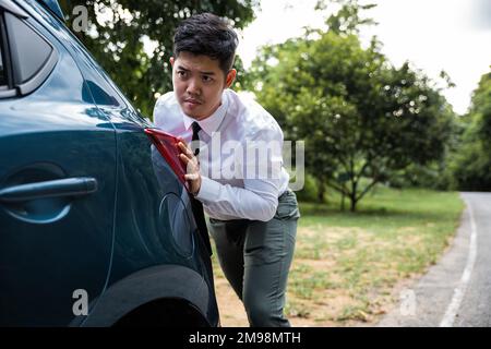 Asian businessman car broken has problems with car down during go to work in morning he pushing out of gas Stock Photo