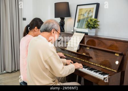 Asian young woman teaching piano for senior man teaching Stock Photo