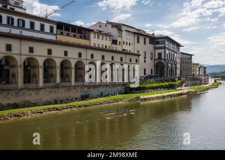 Florence, Italy - April, 15, 2022: Group rowing along the Arno River and past  The Uffizi Gallery Stock Photo