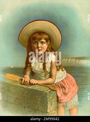 Little girl at the seaside in a wide-brimmed straw hat. Stock Photo