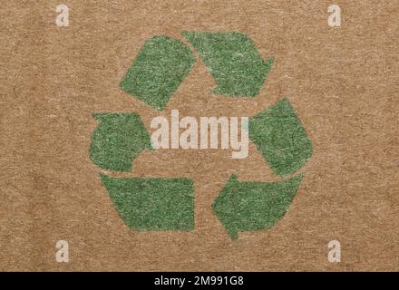 Green recycle symbol printed on a cardboard box, closeup isolated macro view. Stock Photo