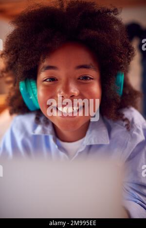 Portrait Of Boy In Bedroom At Night Lying On Bed Using With Laptop Stock Photo