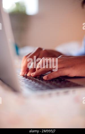 Close Up Of Boy In Bedroom Typing On Keyboard Of Laptop Stock Photo