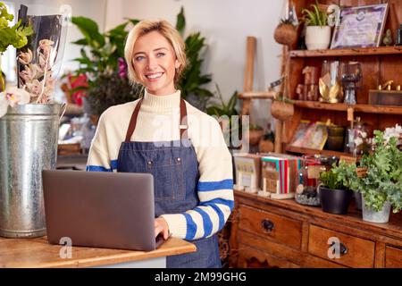 Portrait Of Female Owner Of Florists Shop Using Laptop Stock Photo