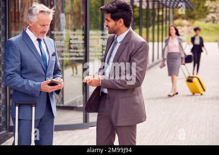 Two Delegates With Luggage Meeting Outside Business Conference Hotel Stock Photo