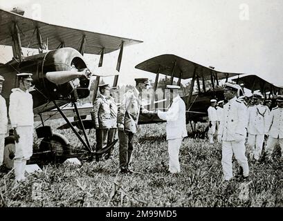 Opening of Aerodrome,Inspection by Vice Admiral Ide. I.J.N., who is shaking hands with Lt Cdr Fowler (in charge of the Flying Section). William Francis Forbes-Sempill, 19th Lord Sempill AFC, AFRAeS (1893-1965) was a Scottish peer and record-breaking air pioneer who was later shown to have passed secret information to the Imperial Japanese military before the Second World War. In 1921, Sempill led an official military mission to Japan that showcased the latest British aircraft. In subsequent years he continued to aid the Imperial Japanese Navy in developing its Navy Air Service and began givi Stock Photo