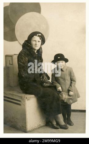 Grimsby - Mother and young daughter in their Sunday best (note the fur coat and leather gloves) pose for a studio portrait photograph with some rather unusual box-shaped props/seating. Stock Photo