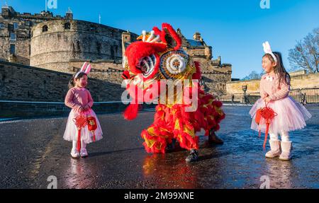 Young Chinese girls wearing rabbit ears entertained by dragon dancers to celebrate Chinese New Year, (Year of rabbit), Edinburgh Castle, Scotland, UK Stock Photo