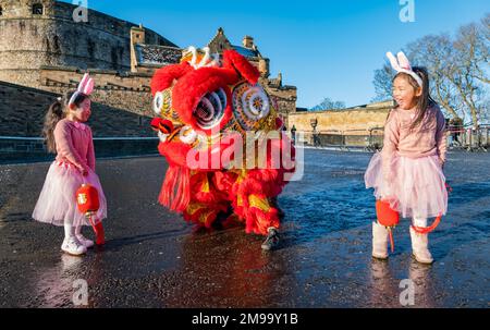 Young Chinese girls wearing rabbit ears entertained by dragon dancers to celebrate Chinese New Year, (Year of rabbit), Edinburgh Castle, Scotland, UK Stock Photo