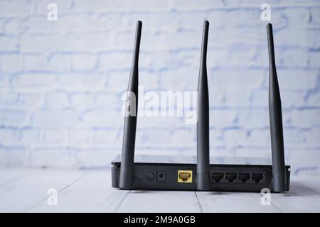 Wi-Fi router with cables on table  Stock Photo