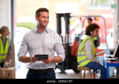 Male Manager In Logistics Distribution Warehouse Using Digital Tablet Stock Photo