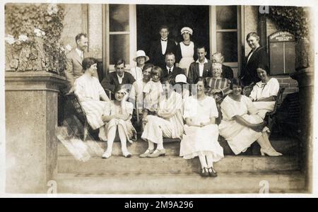 The guests and some of the staff of an unamed Guesthouse. The sign on the right of the doorway reads: 'Orders received for Meguyer's Omnibus' which suggests this photograph was possibly taken on the Isle of Wight as  Meguyer, Sandown and Lake, ran a 'summer only' tourist bus service in the Ventnor - Shanklin - Luccombe area. Stock Photo