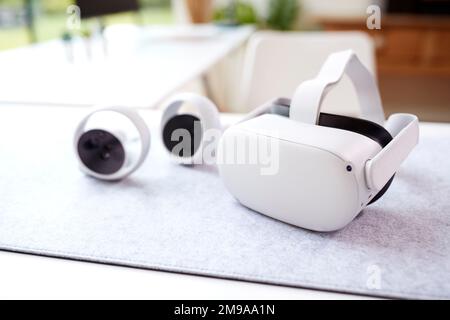 VR Headset And Gaming Controllers On Table At Home Stock Photo