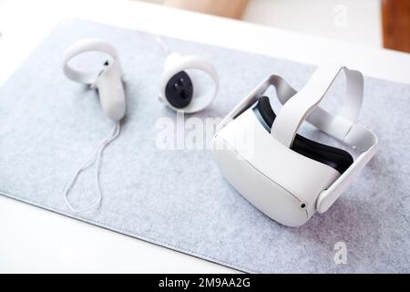 VR Headset And Gaming Controllers On Table At Home Stock Photo