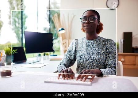 Woman Working From Home Office Looking At Projected Screen Interacting With AR Or VR Technology Stock Photo
