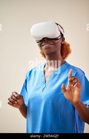 Female Nurse Or Doctor In Scrubs With VR Headset Interacting With AR Technology Stock Photo