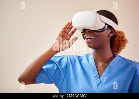 Female Nurse Or Doctor In Scrubs With VR Headset Interacting With AR Technology Stock Photo