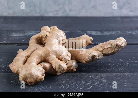 Fresh ginger roots on dark wooden table Stock Photo