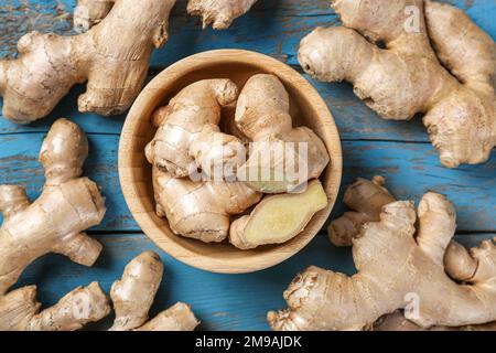 Bowl with ginger roots on wooden table, closeup Stock Photo