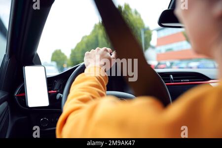 Close Up Of Driver With Hands Free Unit For Green Screen Mobile Phone Mounted On Dashboard Stock Photo