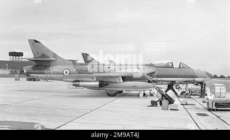 Singapore Air Defence Command - Hawker Hunter FGA.74 '505' (msn 41H/680085, ex XJ632 and G-9-356), on the line with armourers preparing the ADEN gun pack for removal. A replacement gun pack rests on a trolley in the foreground, This aircraft is preserved at Jurong in Singapore. (The Royal Small Arms Factory ADEN, ADEN being an acronym for Armament Development ENfield, is a 30 mm revolver cannon used on many military aircraft, particularly those of the Royal Air Force and Fleet Air Arm. Developed post-World War II primarily to meet Air Ministry's requirement for increased lethality in aircraf Stock Photo